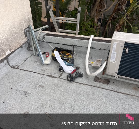 יחידת מזגן חיצונית על גג עם כלי עבודה וצינורות